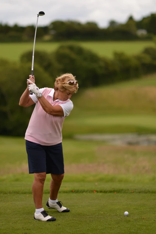 a woman swinging her golf club on the green