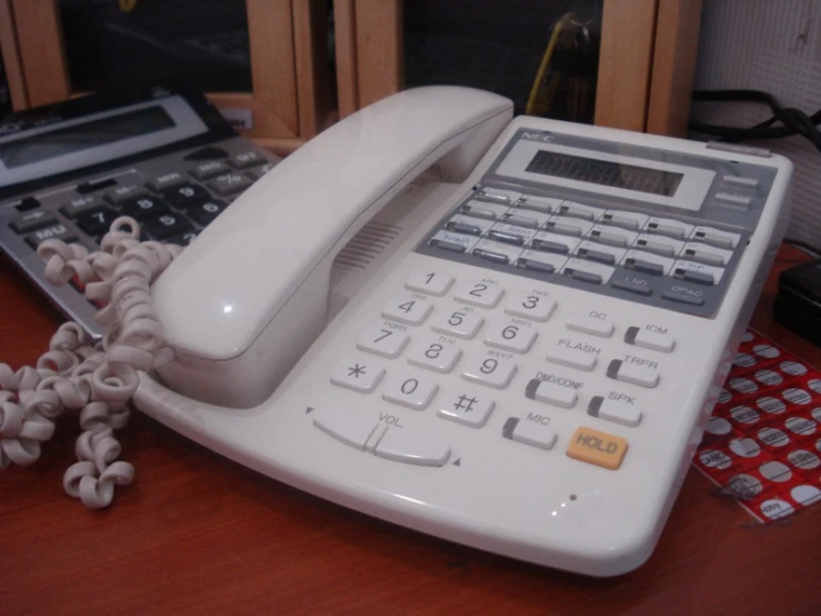 an old telephone next to a book and laptop computer