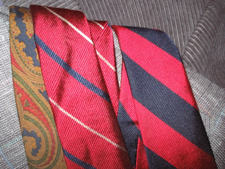 red, grey and blue striped necktie next to a silver sweater