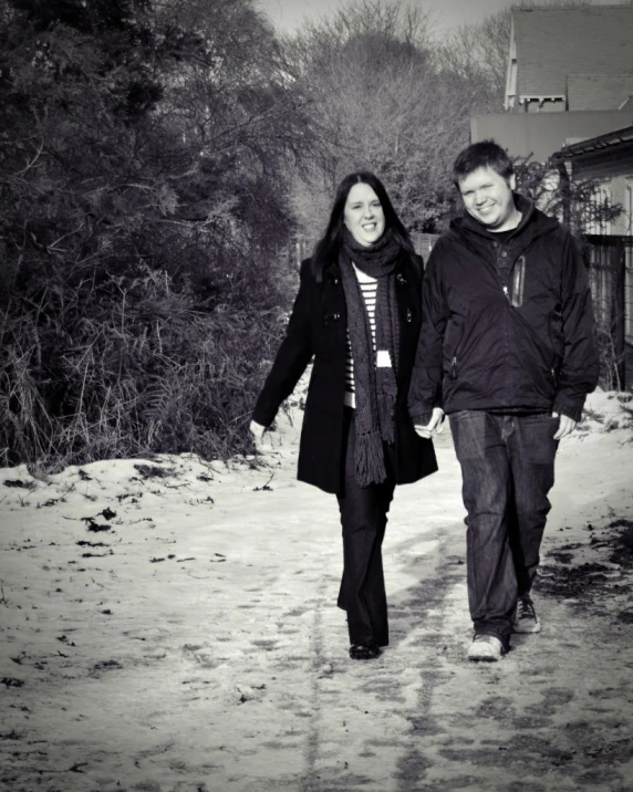 black and white pograph of two people walking down the road