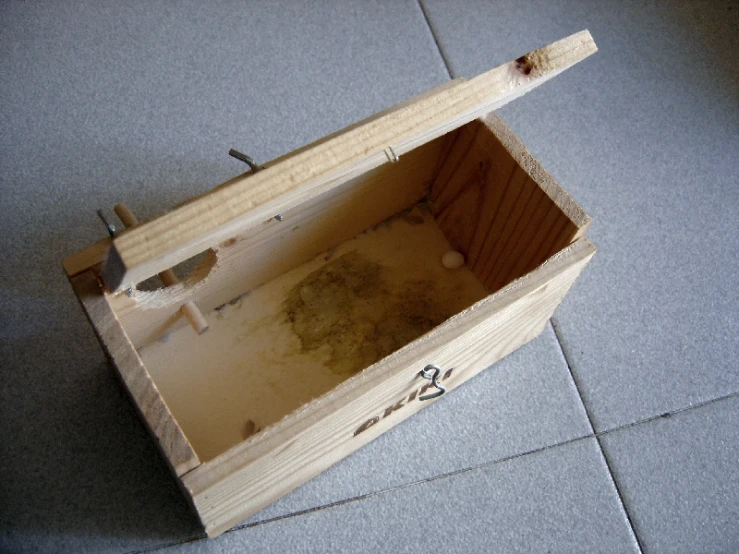 an open box with screws and ink in it on the floor