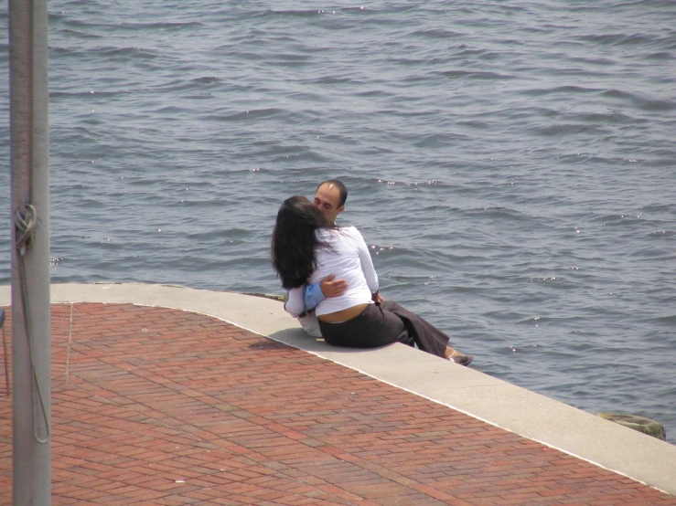 a woman sitting on the edge of a pier