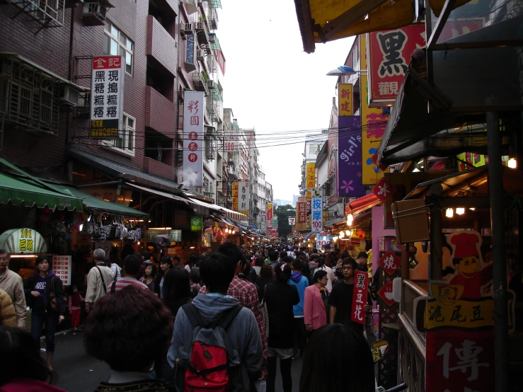 people walking on an asian market looking for things to eat