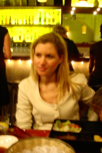 a woman sitting at a restaurant table and making a face