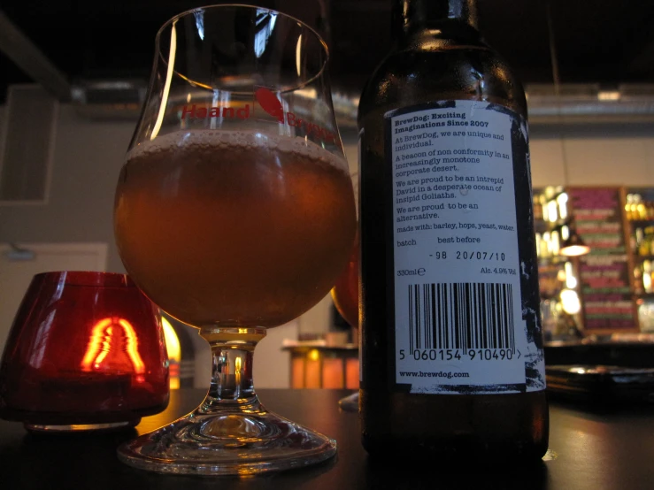 a glass of beer sitting on top of a wooden table