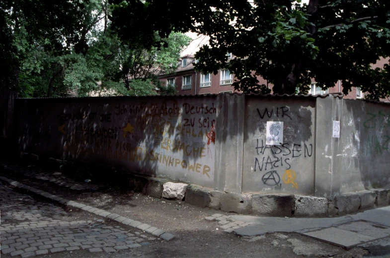 a cement wall with grafitti on it near a road