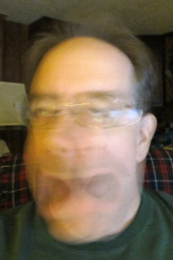 a man wearing glasses is making his face to the camera