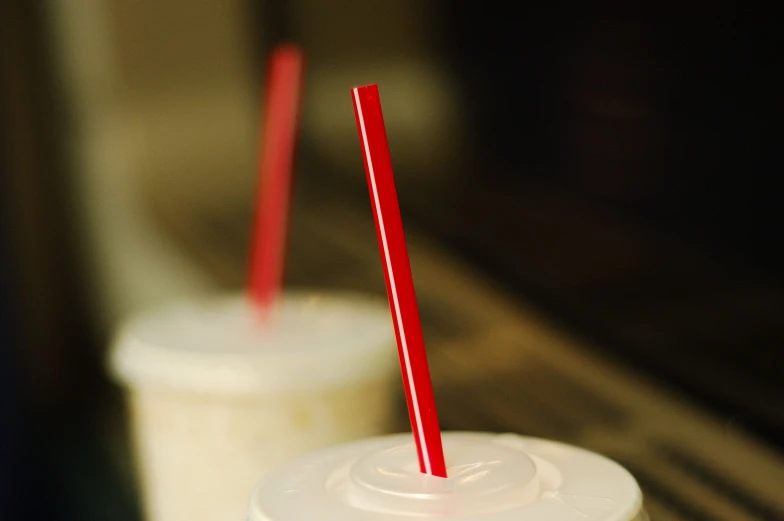 two straws are sticking out of a plastic cup