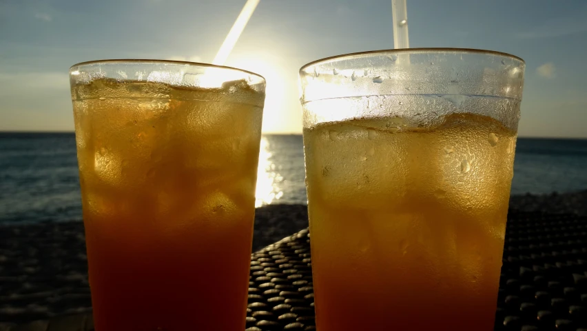 two glasses of soda are sitting on the table