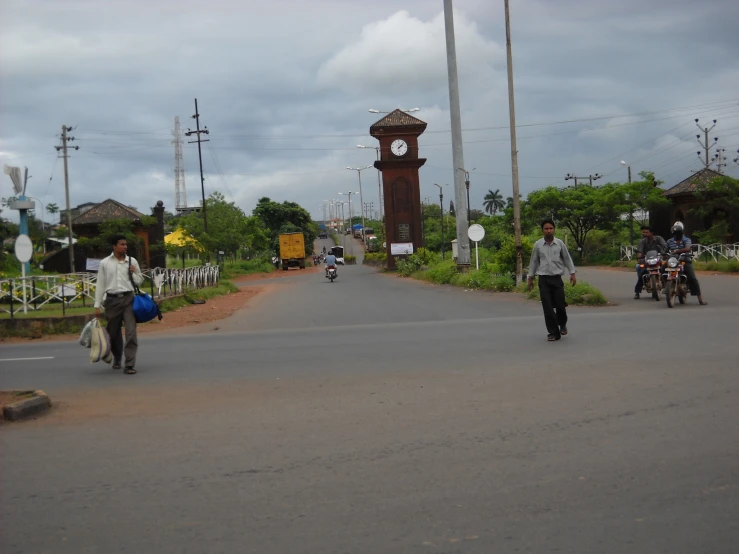 several people ride bikes in front of a clock tower