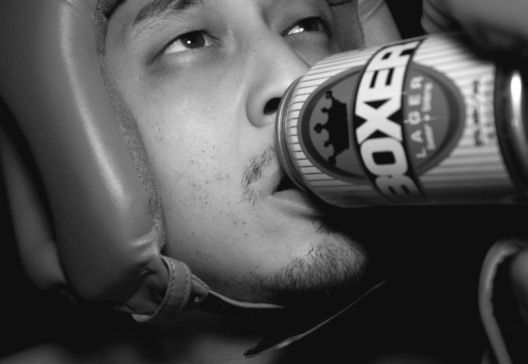 a close up of a person drinking from a beer can
