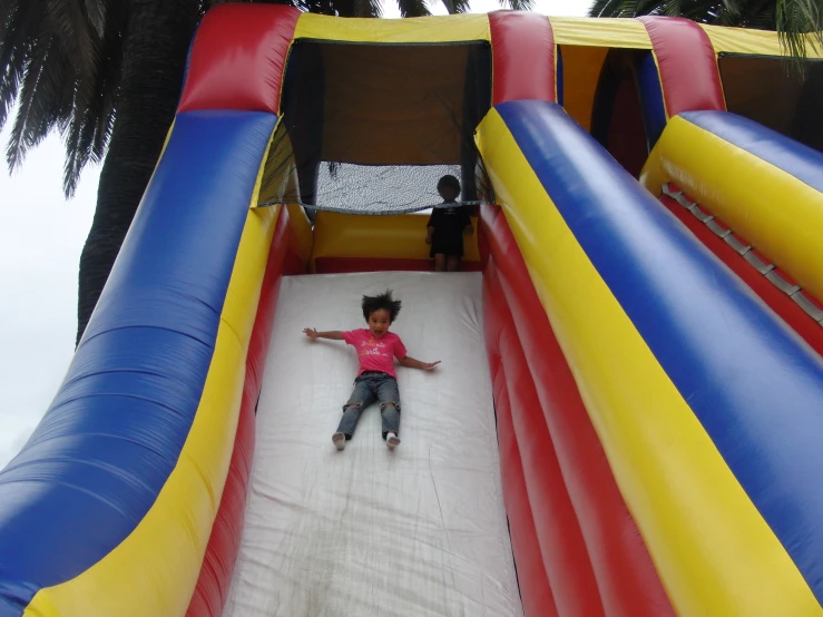 a boy sliding down an inflatable slide