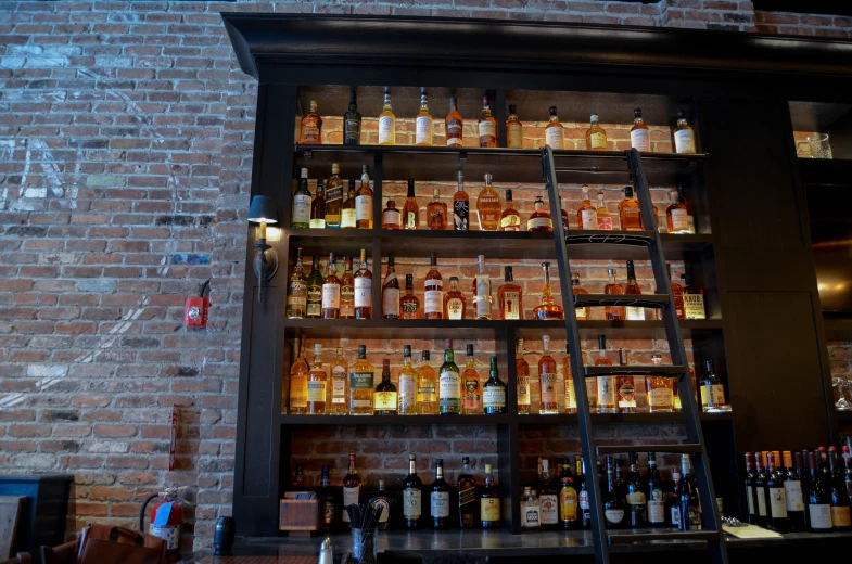 a very large brick wall behind a bar with liquor bottles