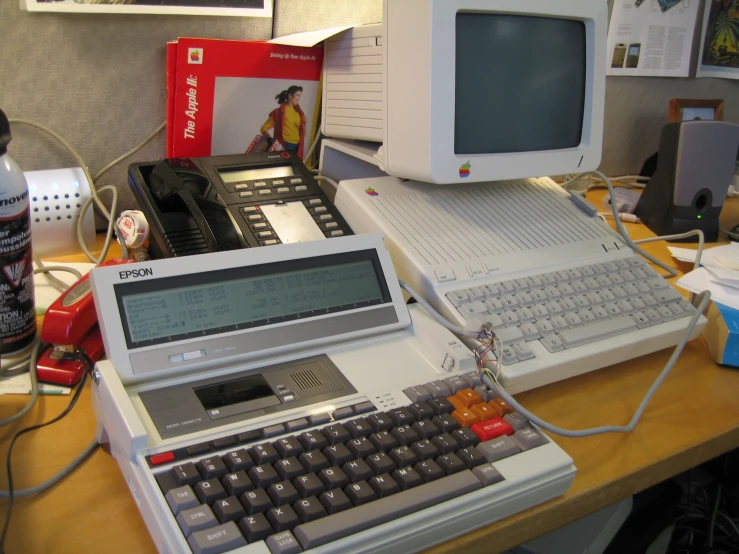 several old and vintage computers sit together on the desk