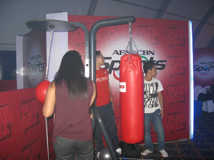 there is a man and a woman standing by a punching bag