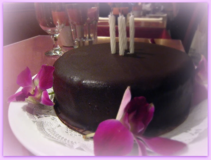 a large chocolate cake with a few candles on it