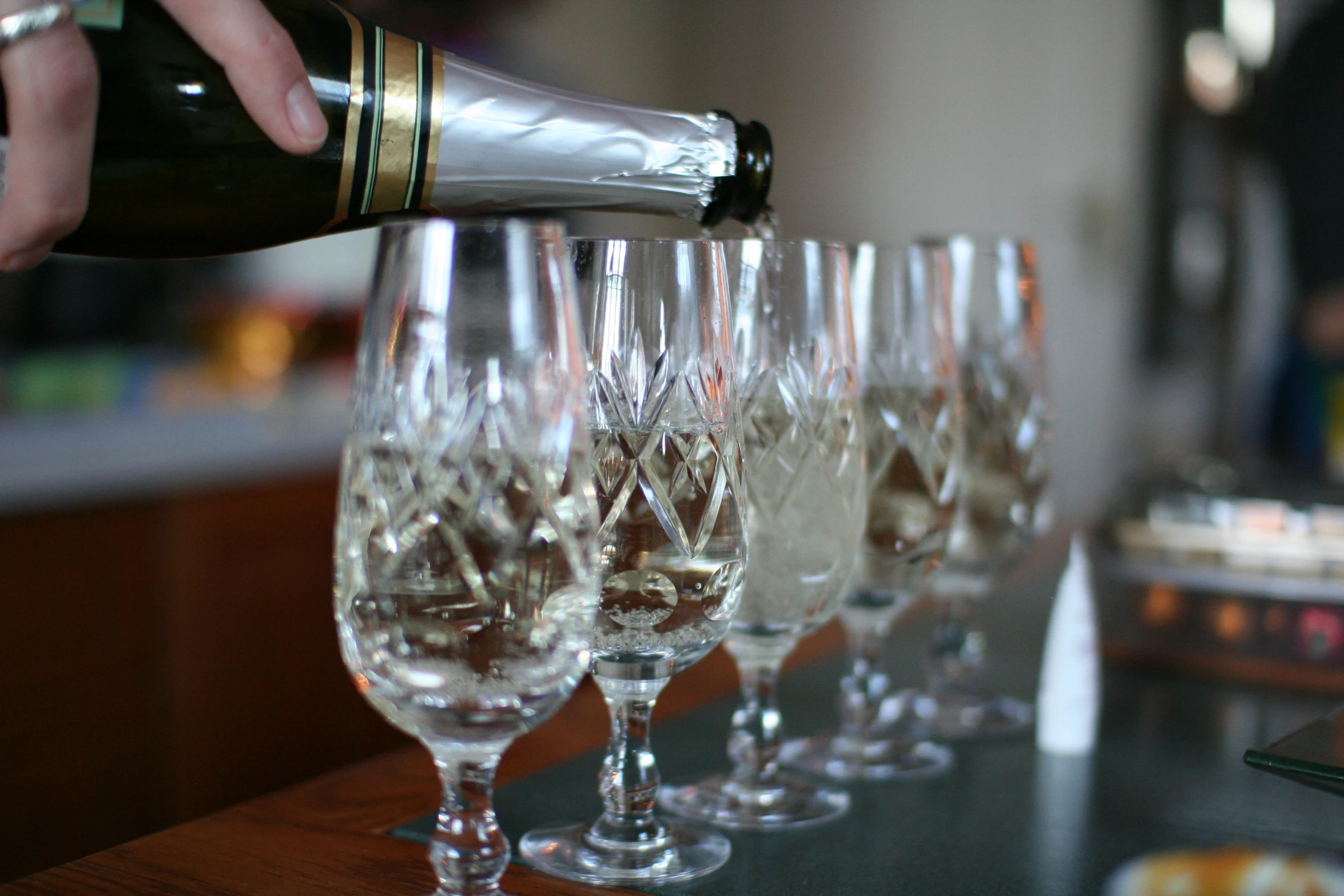 several glasses of wine are shown with a hand pouring