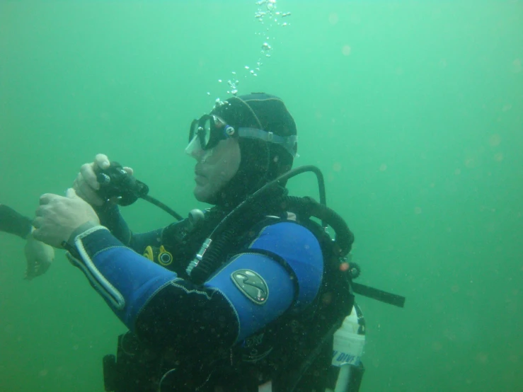 a man holding a scuba stick looking up at the water