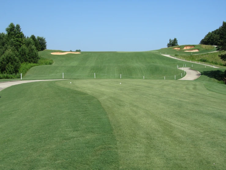 a golf course with several driving paths going up and down the hill