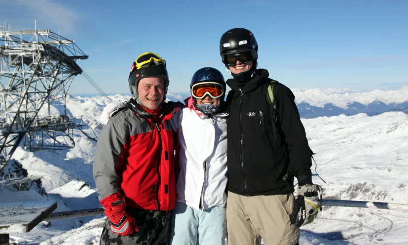 three people pose for a picture in the snow