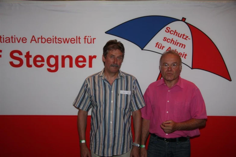 a couple of men standing under a big sign