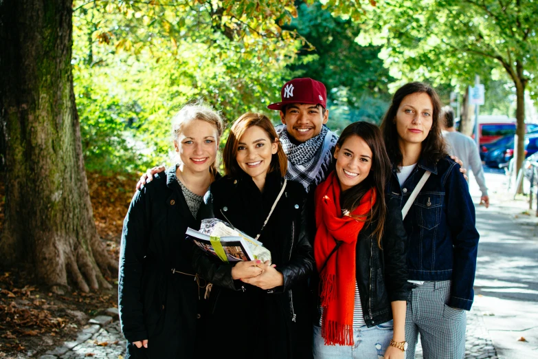 several people standing in front of trees smiling for the camera