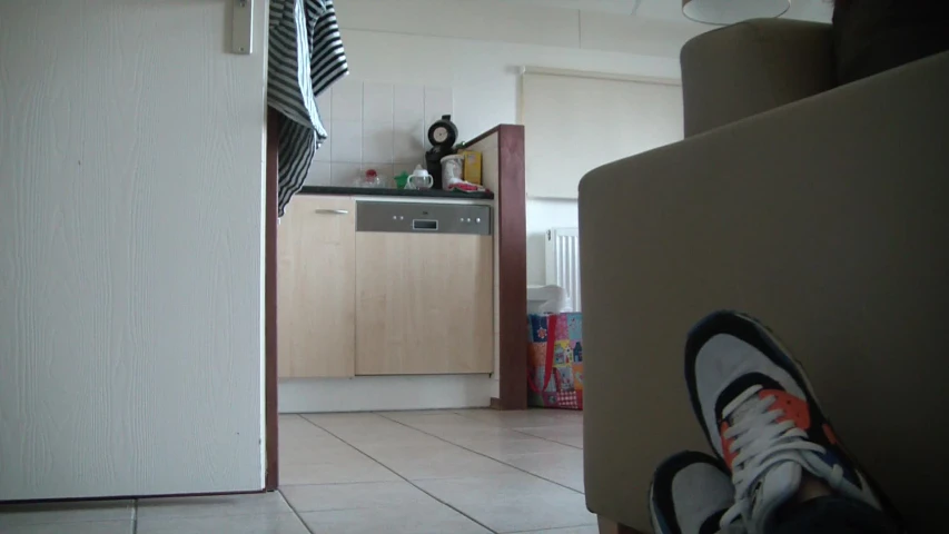 someone standing on a tiled floor in front of an oven