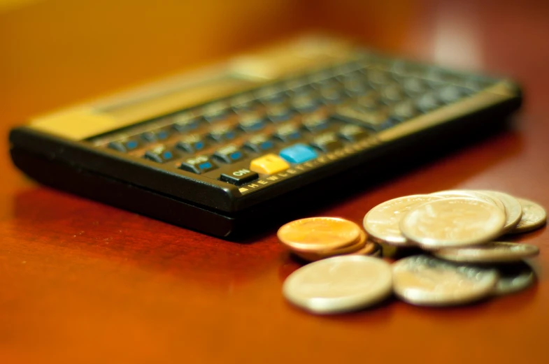 a table top with coins near a calculator