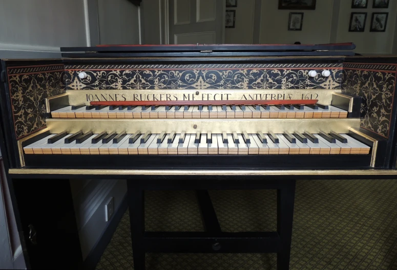 an antique piano with four sections of notes and a red case on it