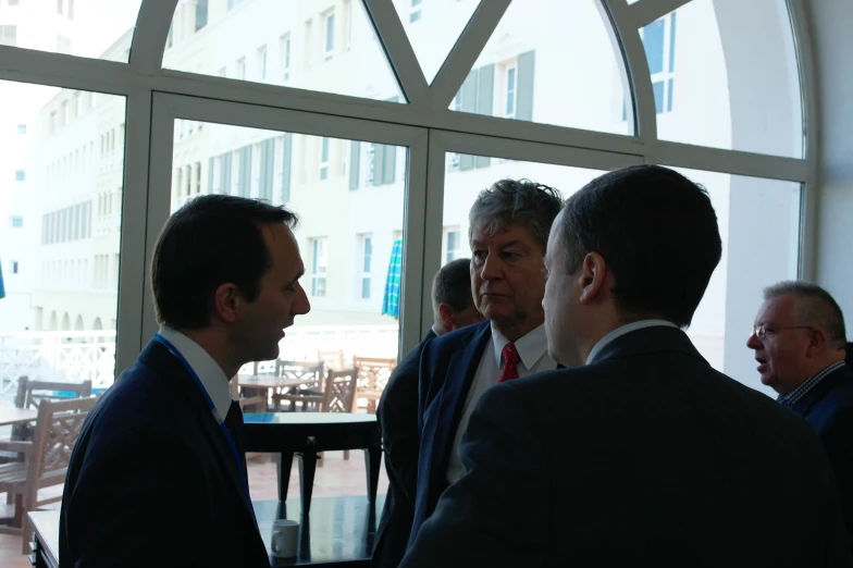 four men in suits standing next to each other