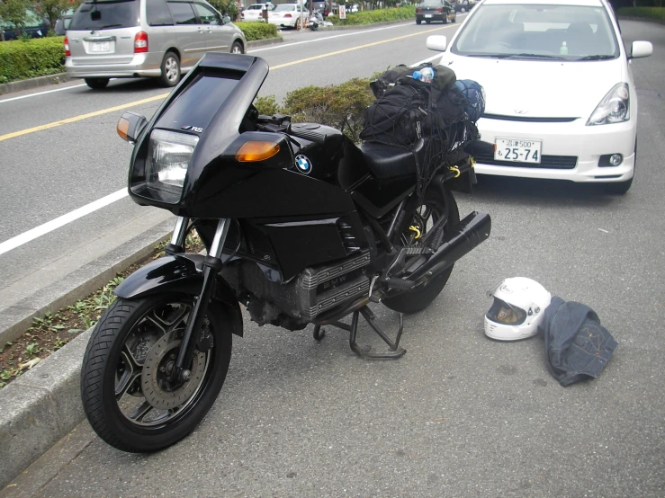 a motorcycle parked next to a car and another car