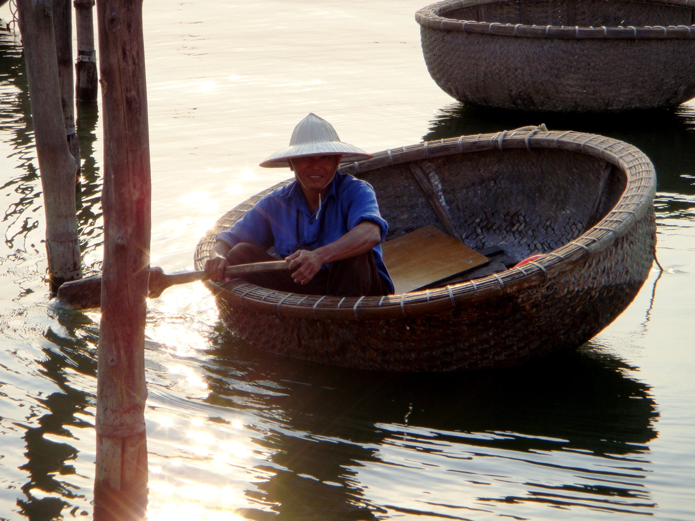 a man sitting in a canoe next to two boats