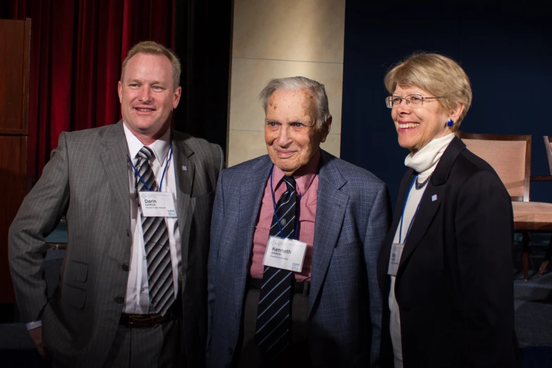 three business people smiling together at an event