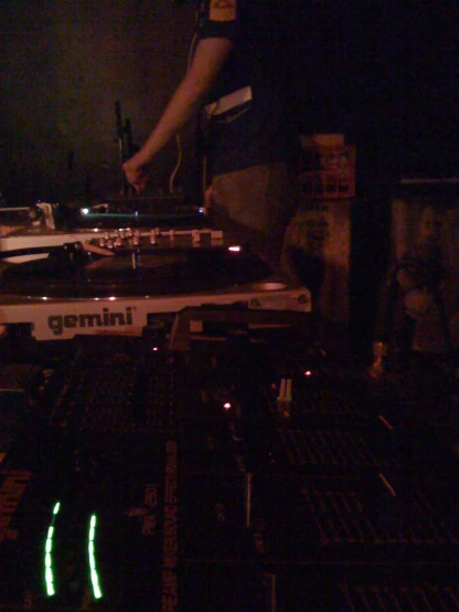 a dj mixes in front of the sound board of a music studio