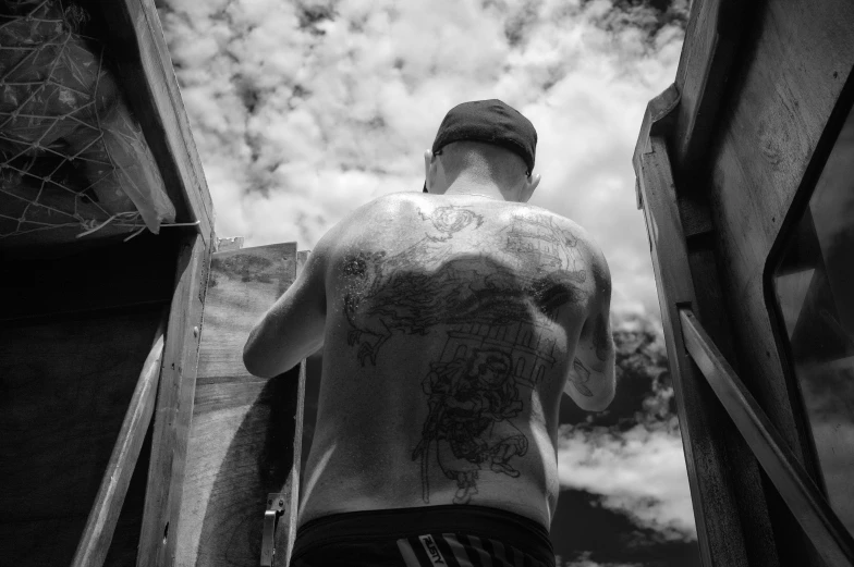 a man with tattoos walking on stairs