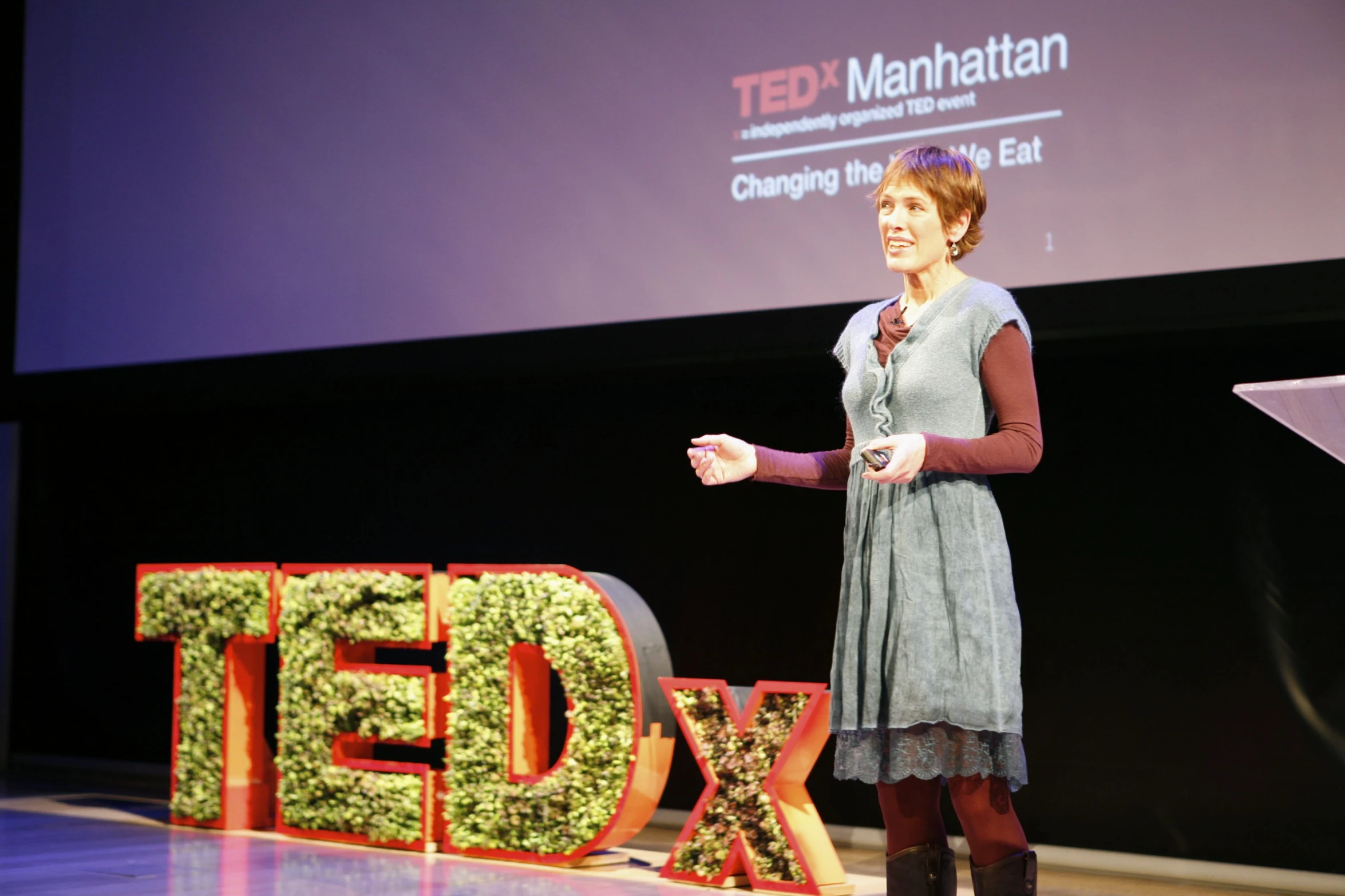 woman stands in front of a ted mark nathan sign