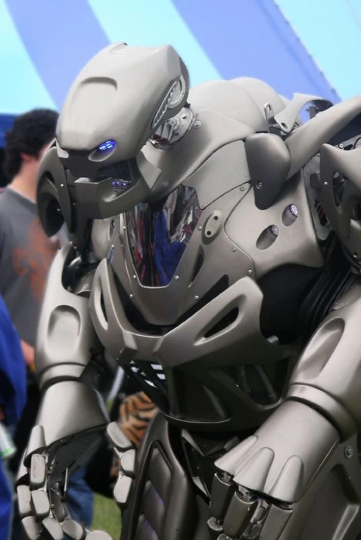 an inflatable, futuristic robot standing by a tent