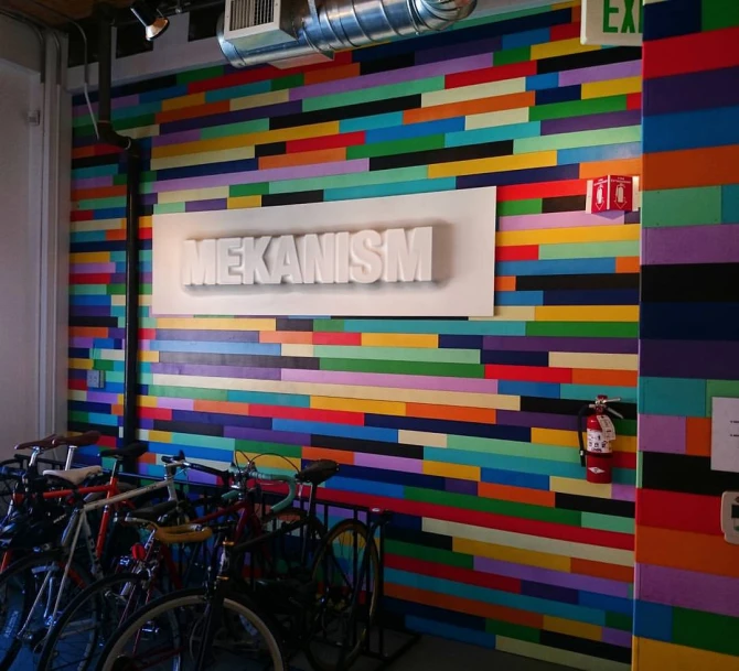 the bicycles are lined up in the colorful wall