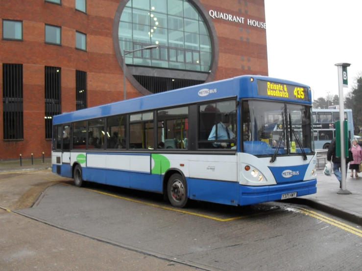 a blue and white bus sitting on a street