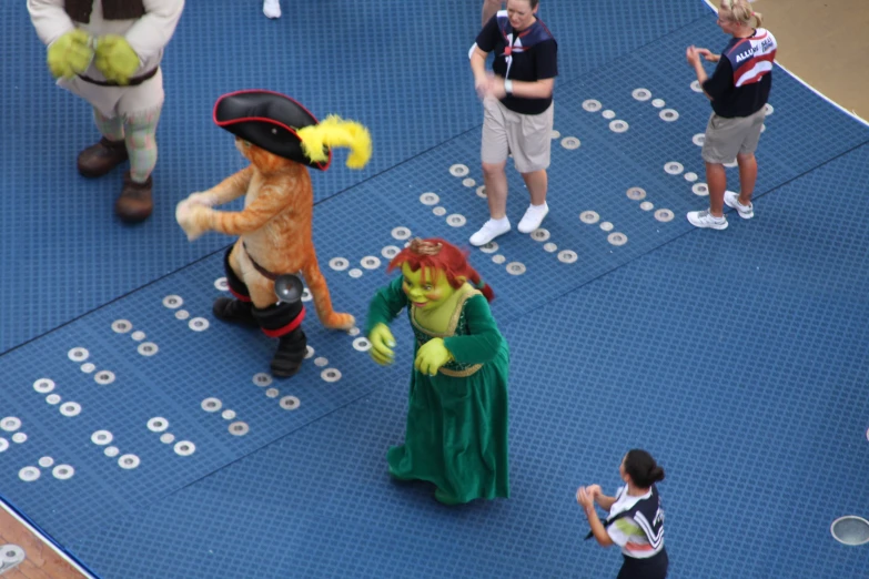 performers in costume walking along on an outdoor stage