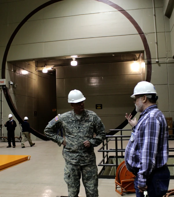 two men in hard hats and a round in an auditorium