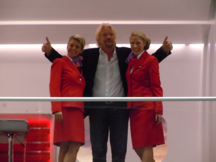 two women wearing red and black with a man