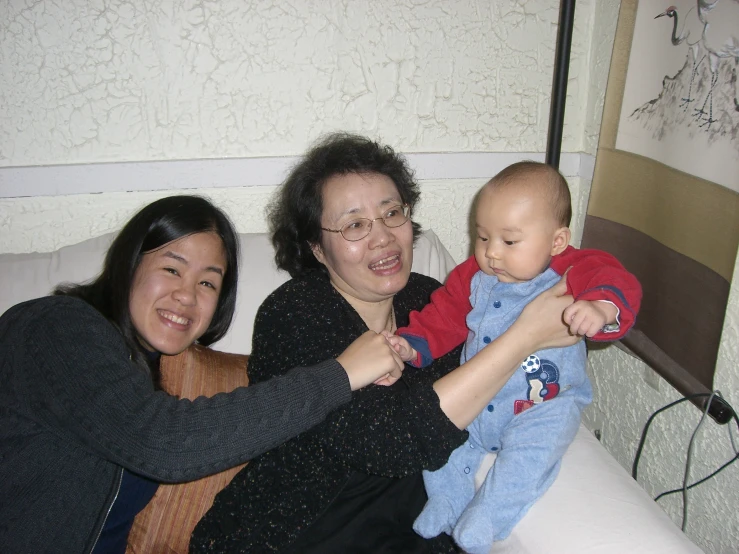 two women, one in black shirt holding a small baby