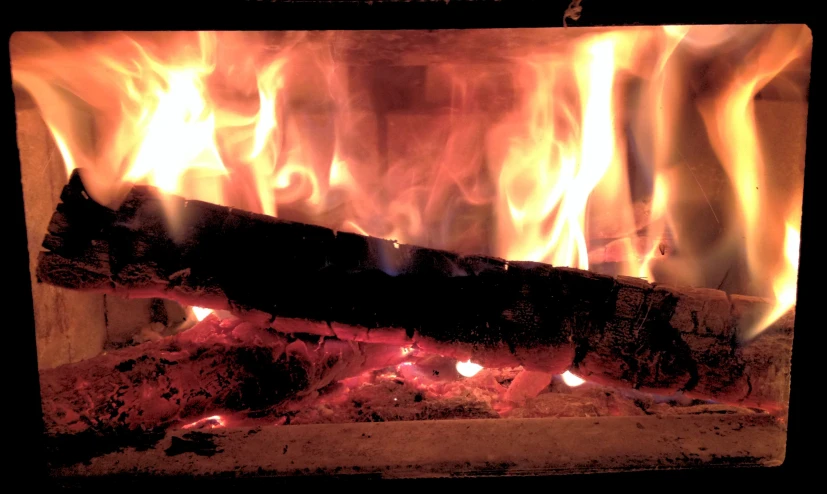 fire blazing over a fireplace in a brick oven