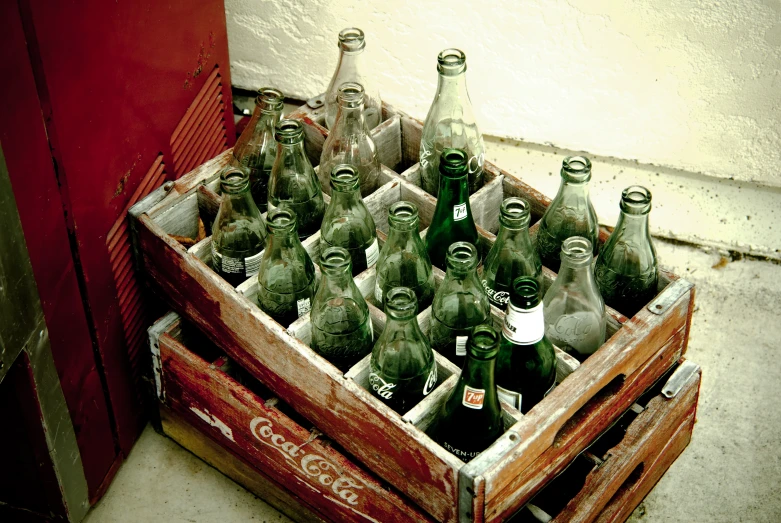 a crate full of soda bottles in front of a red door