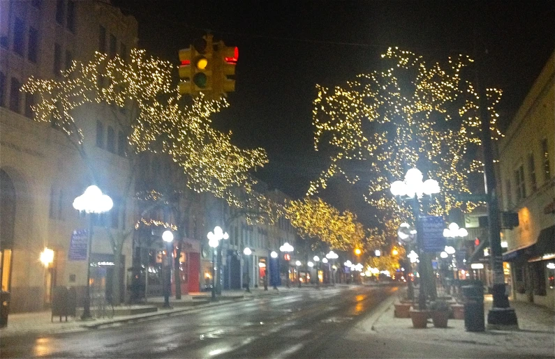 the city street is covered in christmas lights