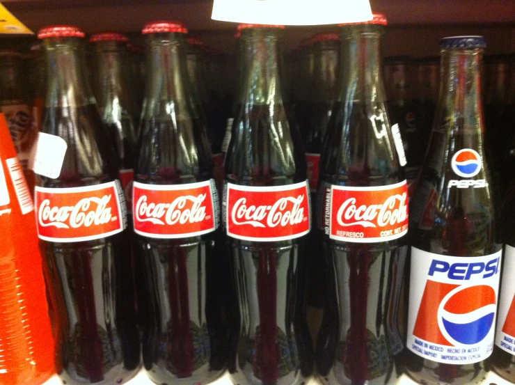 a row of coke colas on display for sale