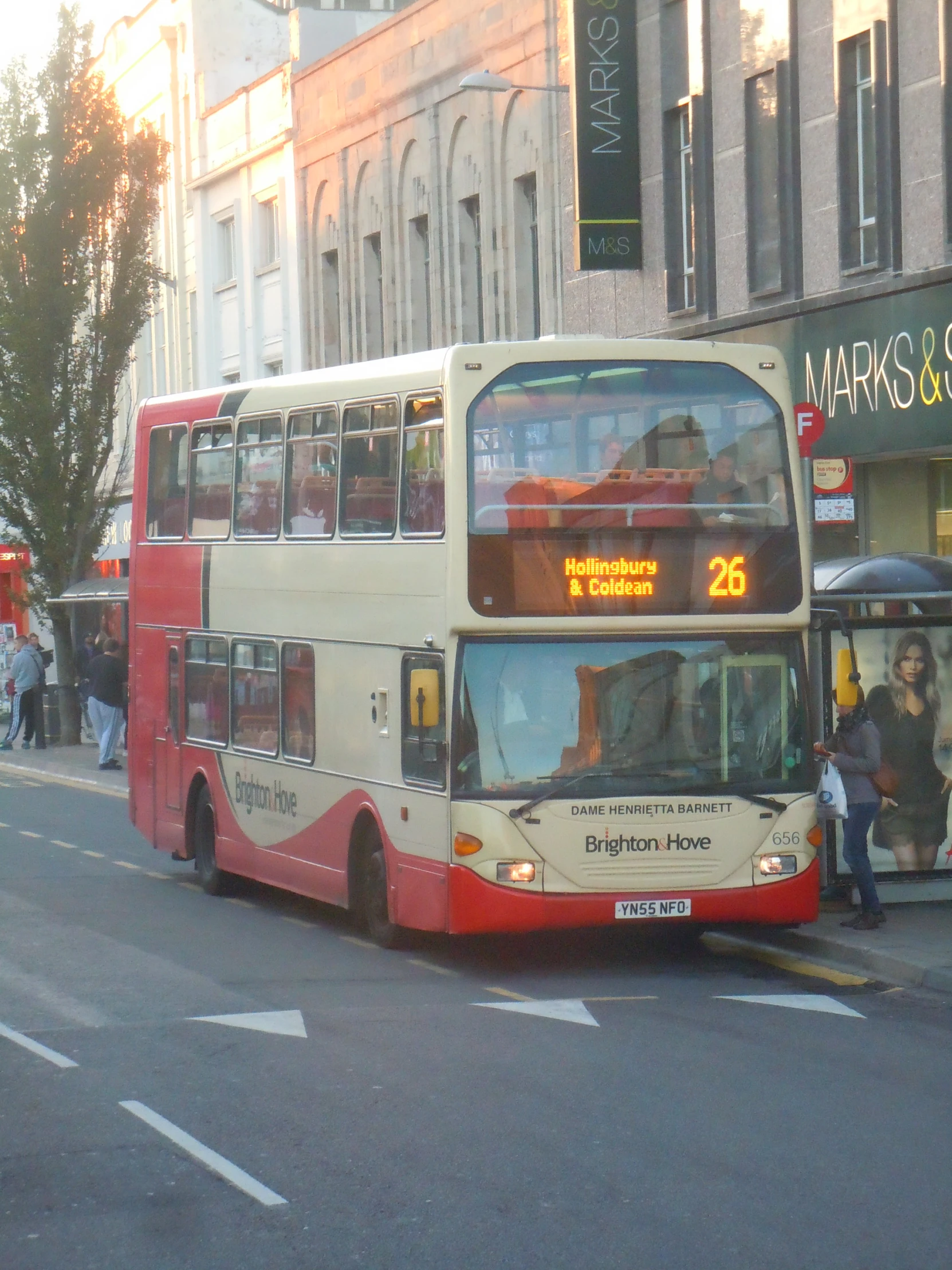 two double decker buses drive down a street next to a sidewalk