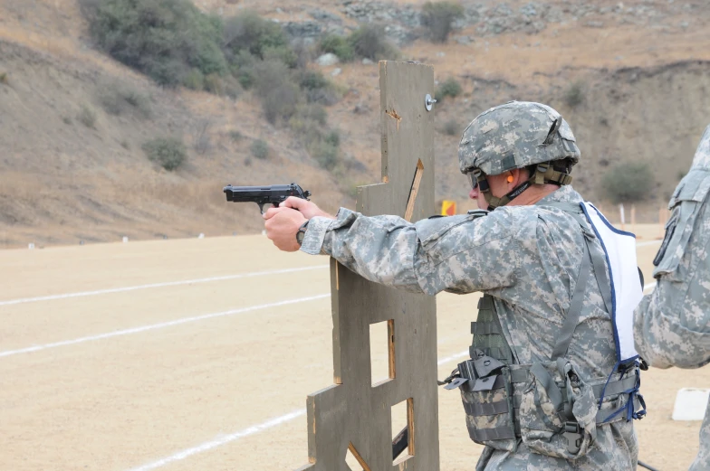 a soldier shooting a gun near some stairs