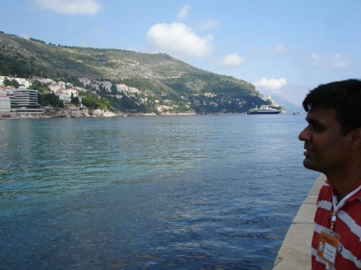 a man is watching as a boat sails by